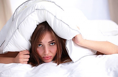 אישה מניחה את הראש מתחת לכרית